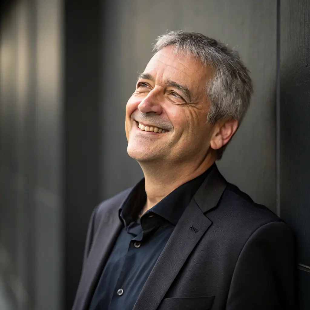 A professional portrait of the president of BASKET CLUB DES TERRES VIVES, a middle-aged man with a friendly smile, wearing a suit.